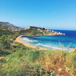 Scenic view of beach against clear blue sky