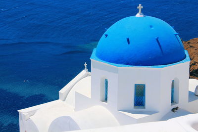 Building by sea against blue sky