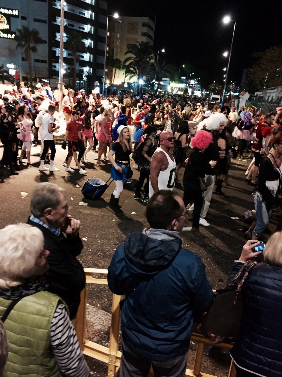 large group of people, lifestyles, men, leisure activity, crowd, person, night, street, casual clothing, togetherness, city, illuminated, event, city life, performance, enjoyment, arts culture and entertainment, mixed age range, sitting