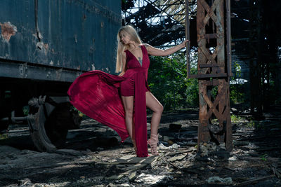 Woman standing against abandoned rusty train