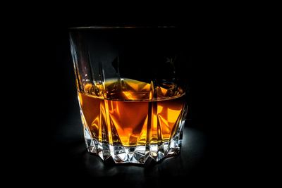 Close-up of beer glass against black background