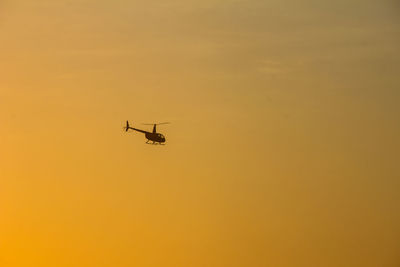 Low angle view of silhouette airplane against sky during sunset