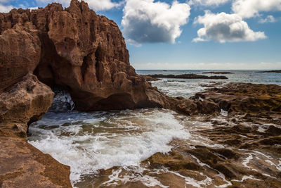 Scenic view of rocks in sea against sky