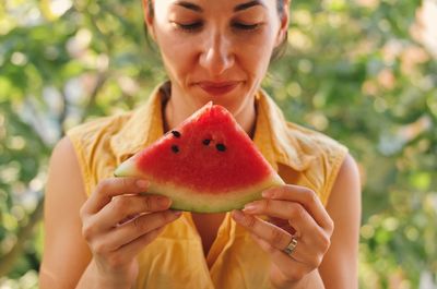 Smiling young woman holding watermelon slice