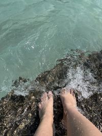 The bare feet of a wet girl on the rocks