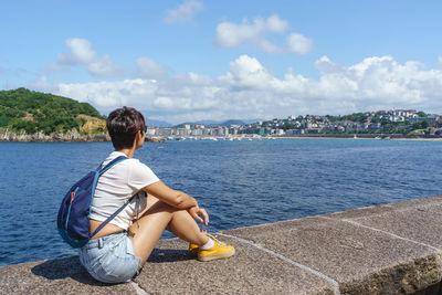 Rear view of woman looking at sea against sky