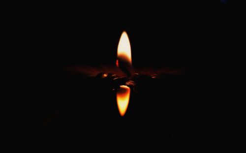 Close-up of lit candle in the dark