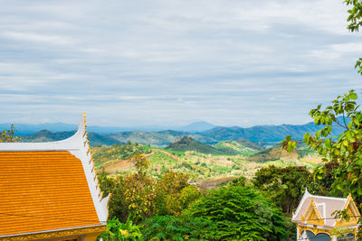 Scenic view of trees and buildings against sky