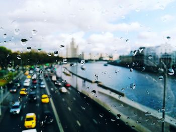 Cars on road seen through wet window during rainy season