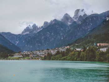 Scenic view of townscape by mountains against sky