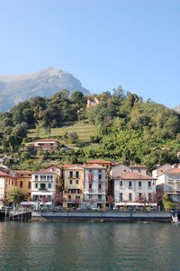 Houses by mountains against clear sky