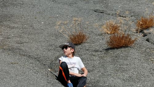 Boy sitting on rock