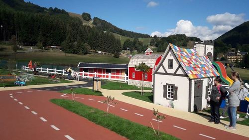 People on road by mountain against sky