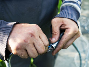 Adult caucasian male pulls cable through metal protective sleeve.