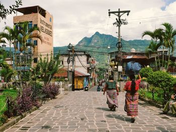 Rear view of women walking on street in city