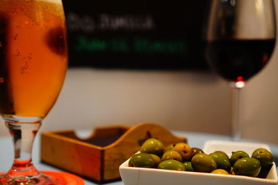 Beer glass and olives on table