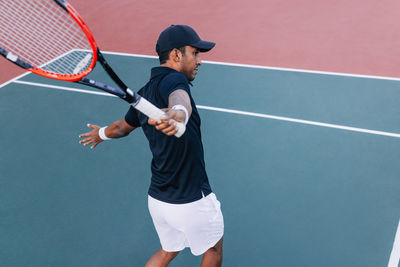 Midsection of man playing tennis