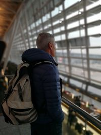 Side view of man standing at airport terminal