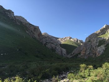 Scenic view of rocky mountains against clear blue sky