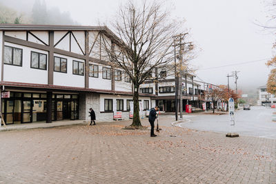 People walking on street against buildings in city