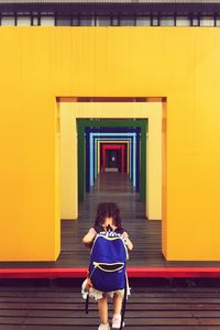 Rear view of people walking in front of building