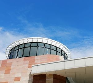 Low angle view of modern building against blue sky