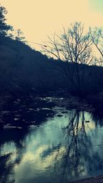 Scenic view of river against sky at sunset