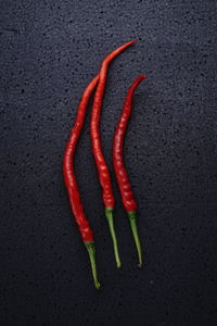High angle view of red chili peppers on black background
