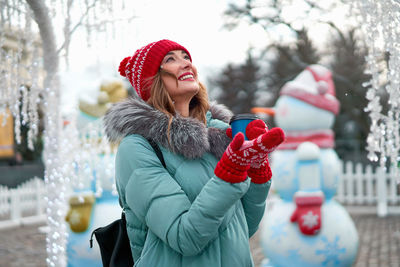 Midsection of woman with umbrella in snow