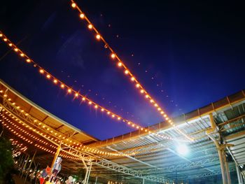 Low angle view of illuminated city against sky at night