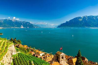 Scenic view of sea by buildings against blue sky