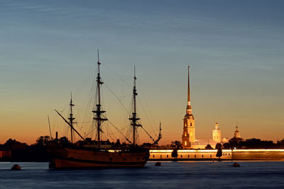 Sailboats in sea at sunset