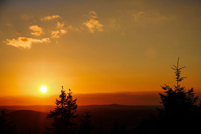 Scenic view of silhouette landscape against orange sky