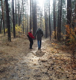 Lovers walking hand in hand in autumn park