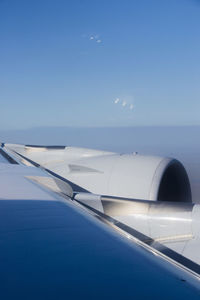 Airplane flying over sea against clear blue sky