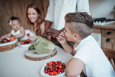 High angle view of friends and fruits on table