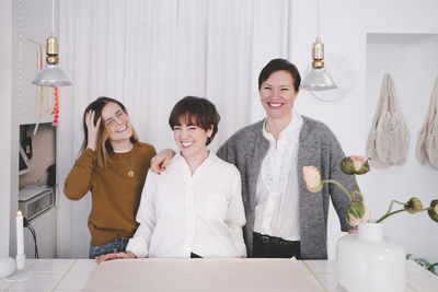 Portrait of smiling female design professionals standing at desk in studio