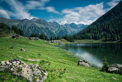 Scenic view of green landscape and mountains against sky