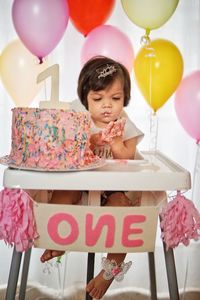 Low angle view of girl with balloons at home