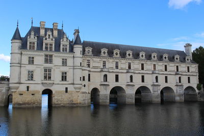 Arch bridge over river against buildings