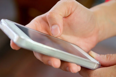 Close-up of hands holding mobile phone