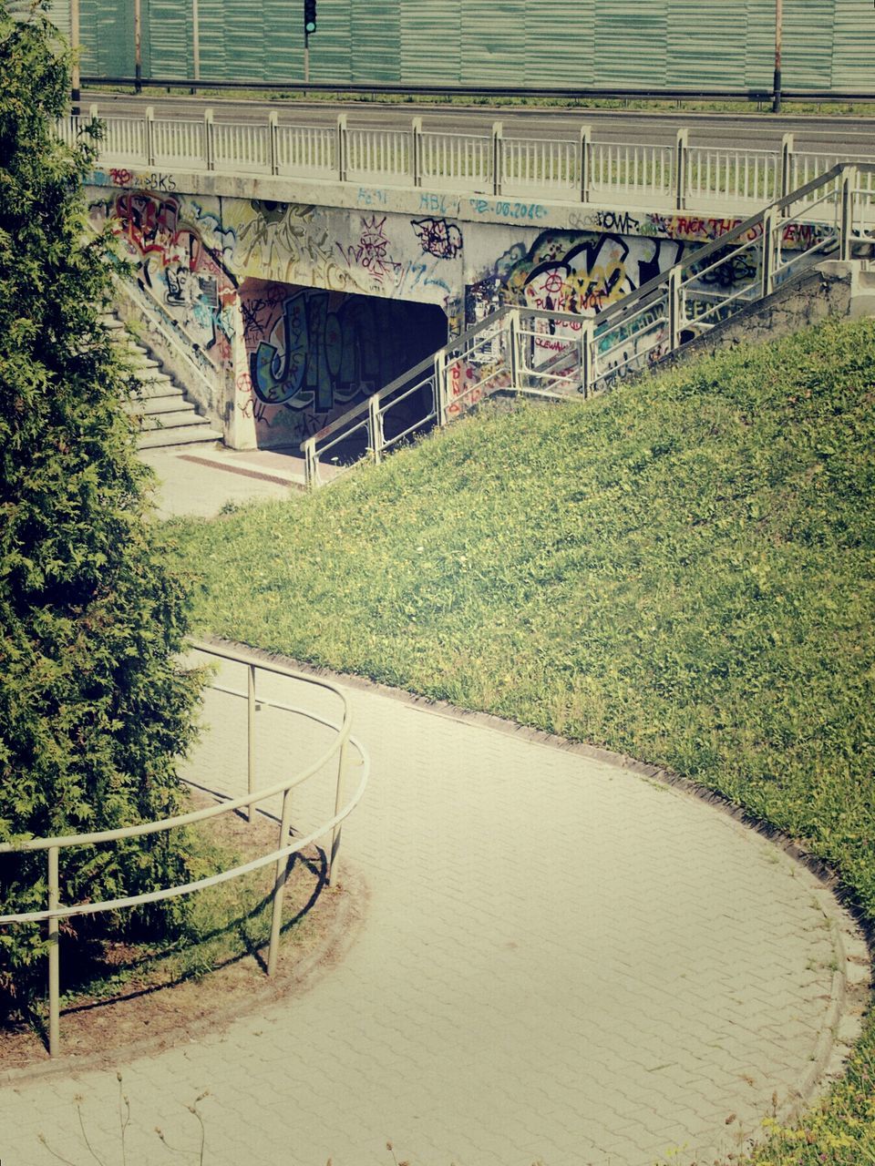 architecture, built structure, grass, building exterior, transportation, green color, plant, the way forward, day, tree, high angle view, outdoors, empty, railing, growth, no people, sunlight, road, footpath, diminishing perspective