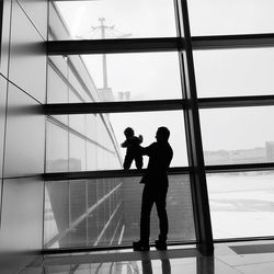 Father holding son on window frame
