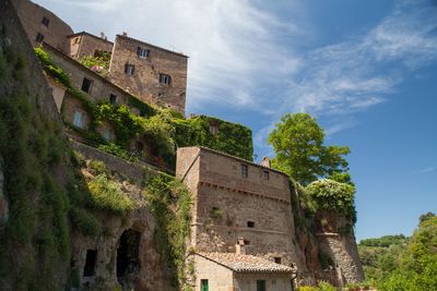 Low angle view of historic building of sorano  in tuscany against sky
