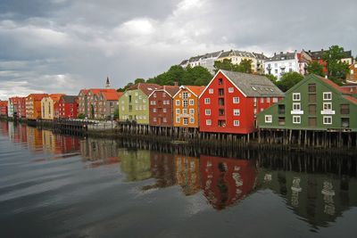 Reflection of houses in water against sky