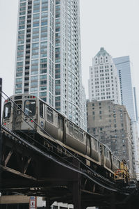 Low angle view of train in city against clear sky