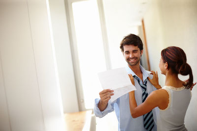 Man holding paper by woman at home