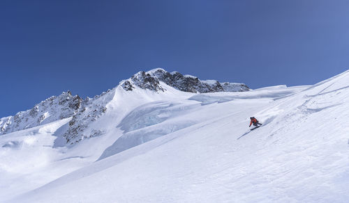 Person skiing on snowcapped mountain against sky