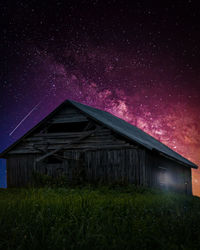 House on field against sky at night