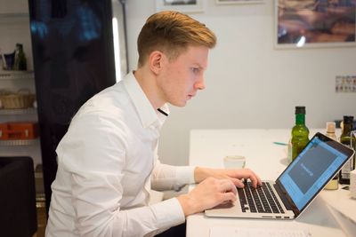 Focused businessman using laptop at home